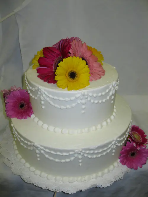 Wedding cake: Daisies #1. Vanilla buttercream. Flowers provided by customer.