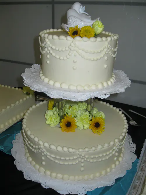 Wedding cake: Pillars #1. Cream cheese icing. Flowers provided by customer.