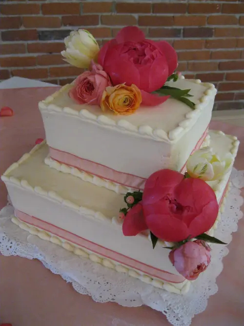 Wedding cake: Square #2. Vanilla buttercream. Flowers and ribbon provided by customer.